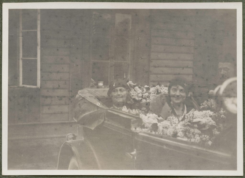Zofia Mussilowa i Olga Różecka (?) w odkrytym samochodzie wśród kwiatów, portret