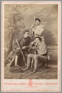 3 mężczyzn w strojach myśliwych