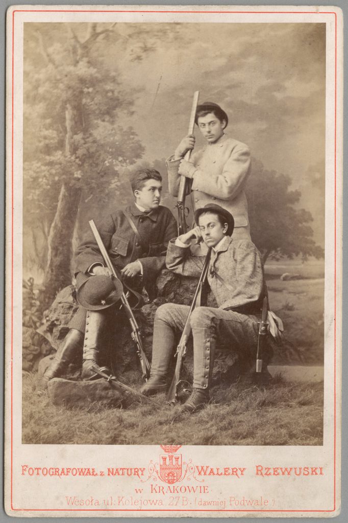 3 mężczyzn w strojach myśliwych