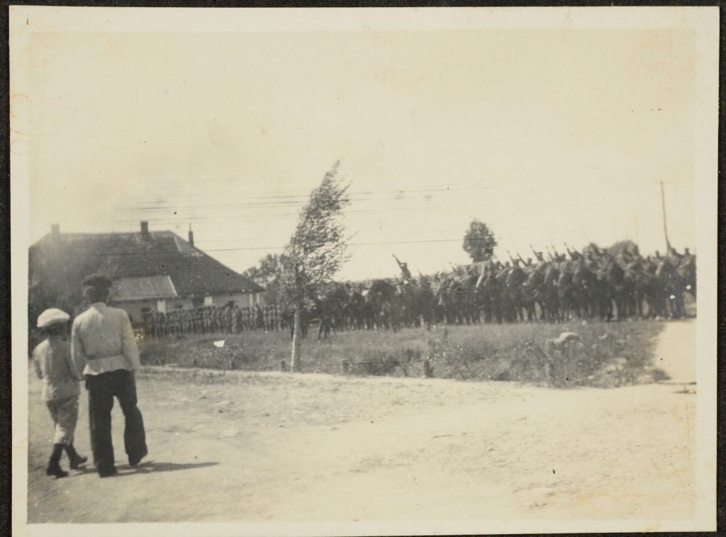 Kawalerzyści z obnażonymi szablami.