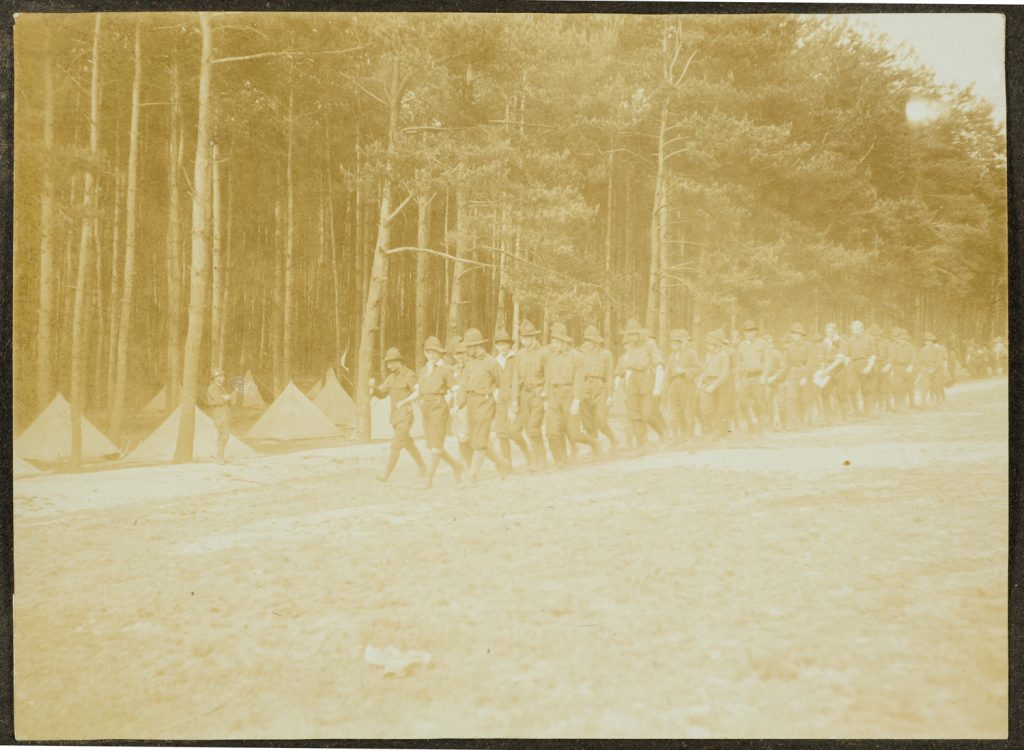 Grupa skautów maszeruje przez obóz