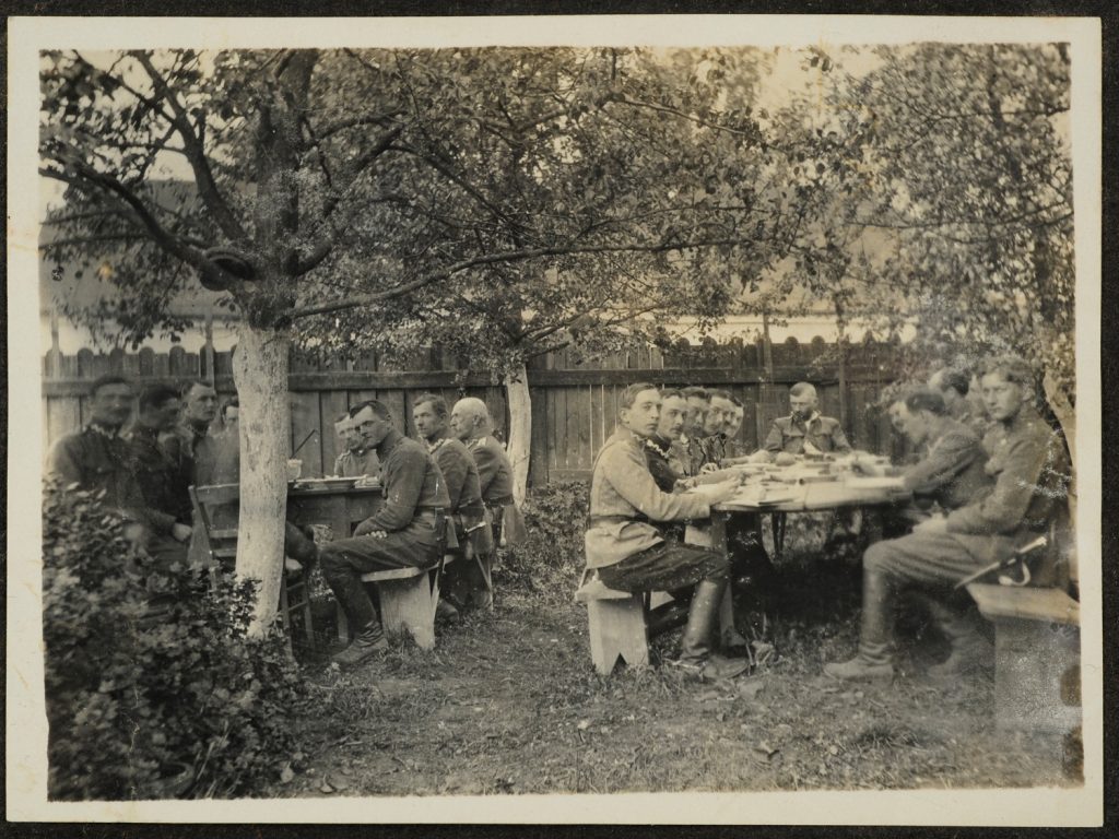 Żołnierze w sadzie przy posiłku