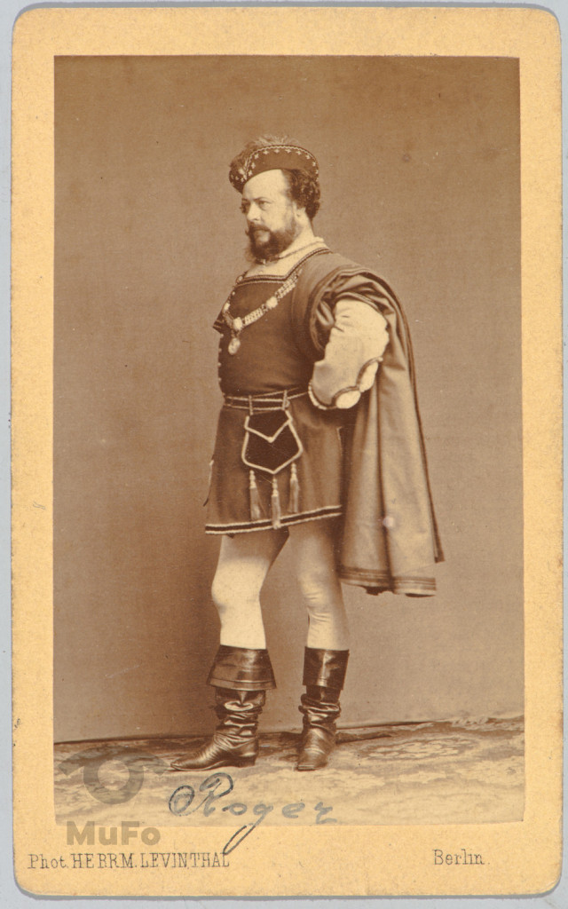 aktor w kostiumie hist. ( Roger ), portr. całopostaciowy, w atelier