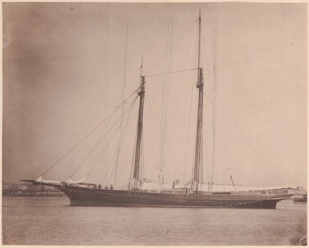 Jacht stoi na kotwicy, w tle port