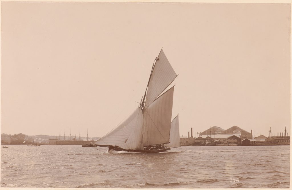 Płynący jacht na tle portu Pula.