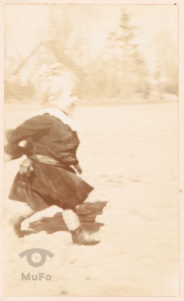 Dziecko (dziewczynka ok. 3 lat) biegnące przez podwórko