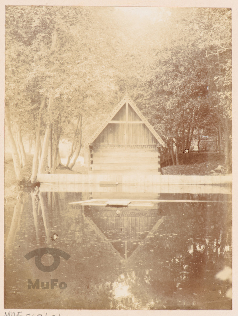 Drewniany budynek nad stawem.