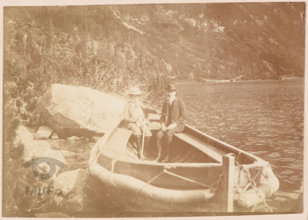 Mężczyzna i chłopiec w drewnianej łodzi.