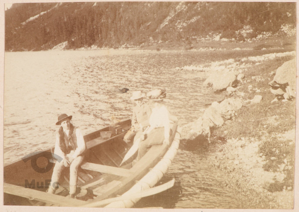 Kobieta i chłopiec, młody góral w drewnianej łodzi.