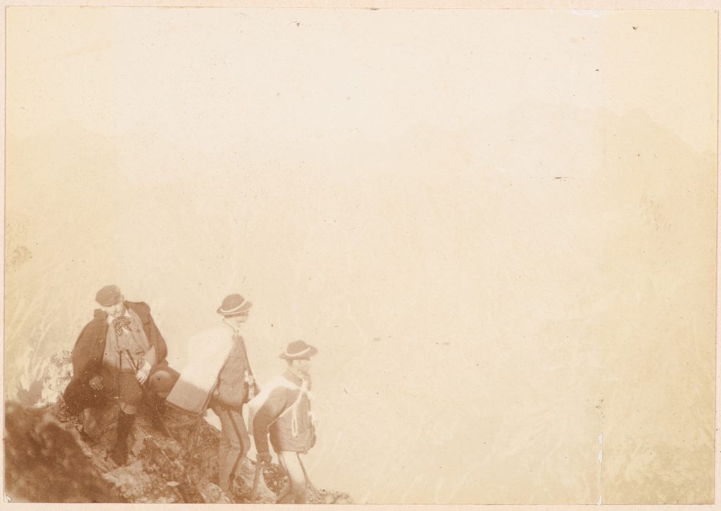 Turysta i dwaj górale na tle panoramy Tatr