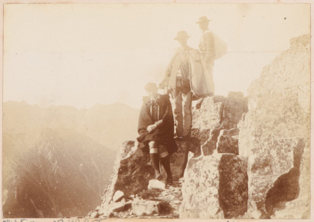 taternik z przewodnikami na tle panoramy Tatr Wysokich