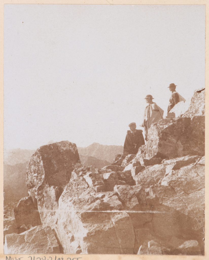 Taternik z przewodnikami na tle panoramy Tatr Wysokich