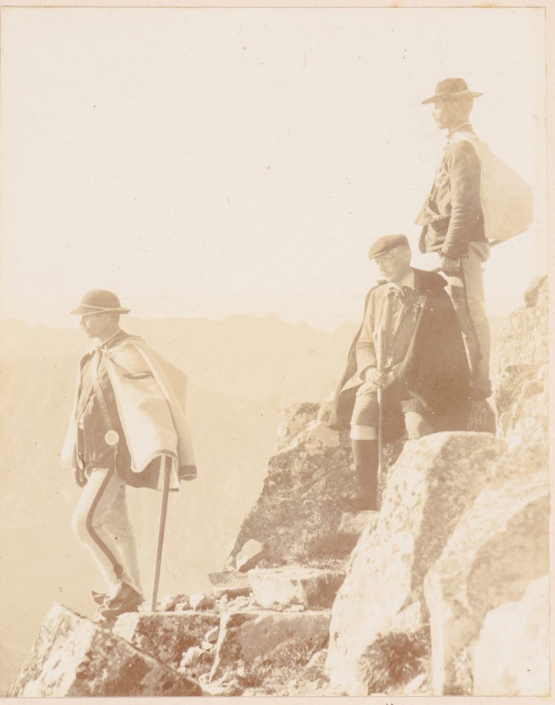 Taternik z przewodnikami na tle panoramy Tatr Wysokich