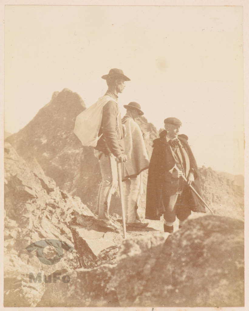 Taternik z przewodnikami na tle panoramy Tatr Wysokich