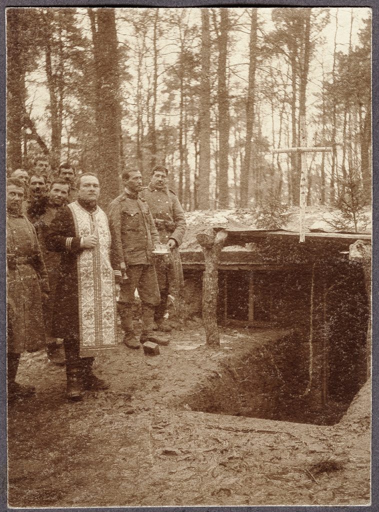 wojskowi  w płaszczach i mundurze armii austro-węgierskiej wraz z kapelanem, portret zbiorowy w plenerze w lesie przy ziemiance - kaplicy, fot. z albumu zw. temat. z frontem ros. w cz.I wojny świat.