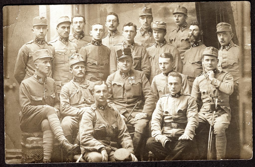 18. żołnierzy  w mundurach polowych armii austro-węgierskiej, portret zbiorowy we wnętrzu atelier, fot. z albumu zw. temat. z frontem ros. w cz.I wojny świat.