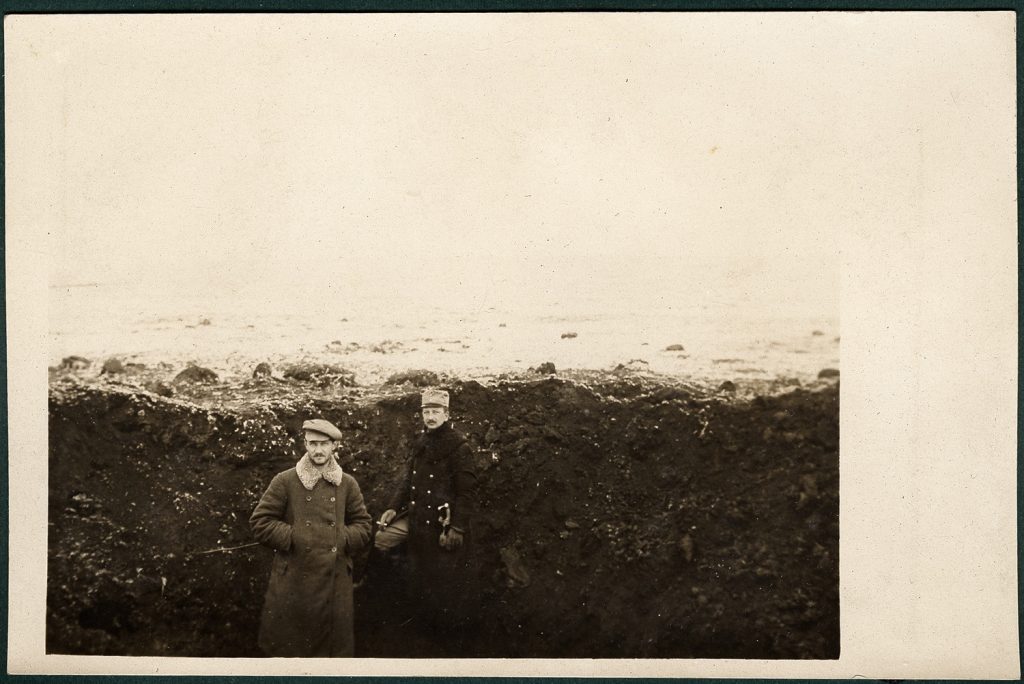 dwaj mężczyźni we wnętrzu wykopu - leju po pocisku.