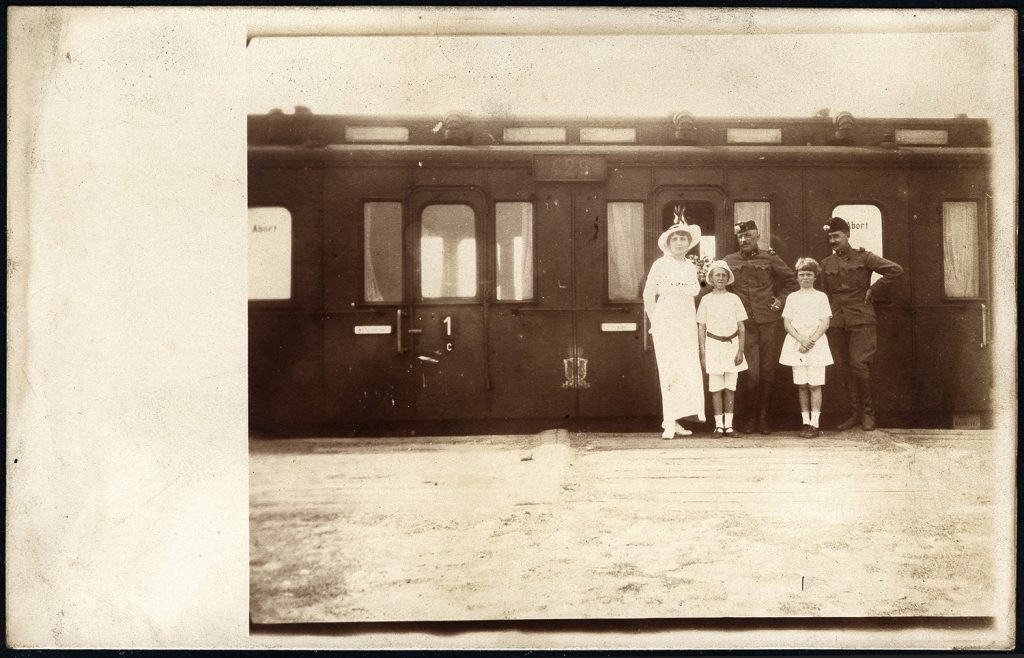 grupa osób przed wagonem kolejowym