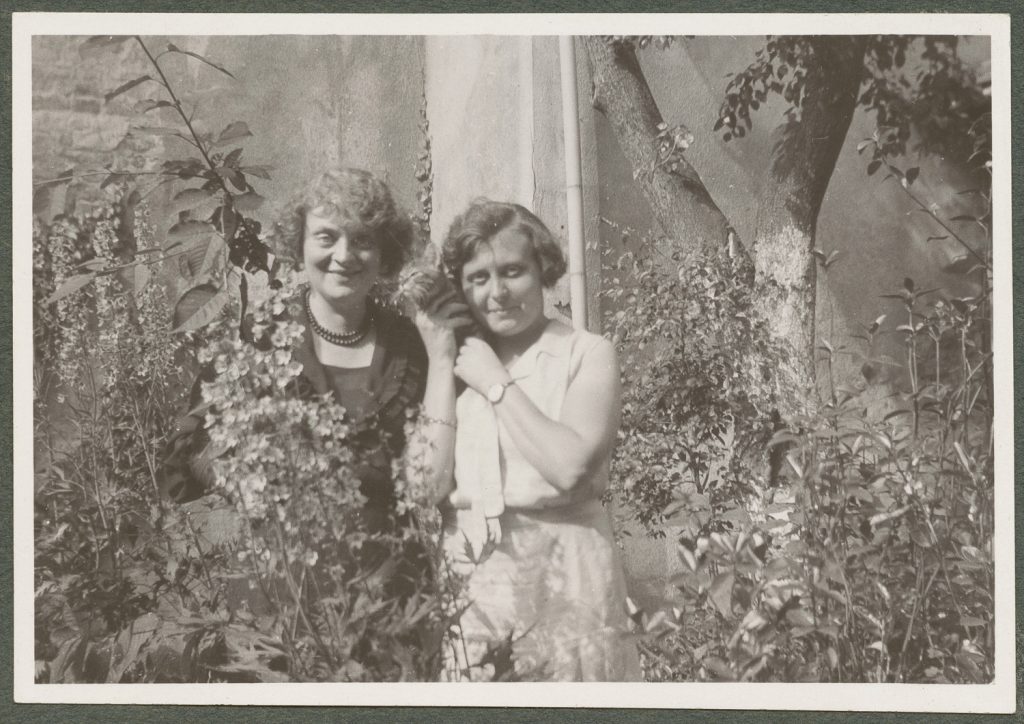 Dwie kobiety z kotem w ogrodzie, portret w plenerze