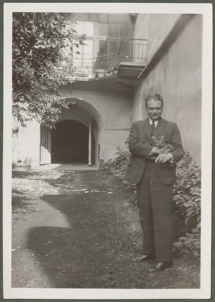 Paweł Mussil z kotem na dziedzińcu, portret