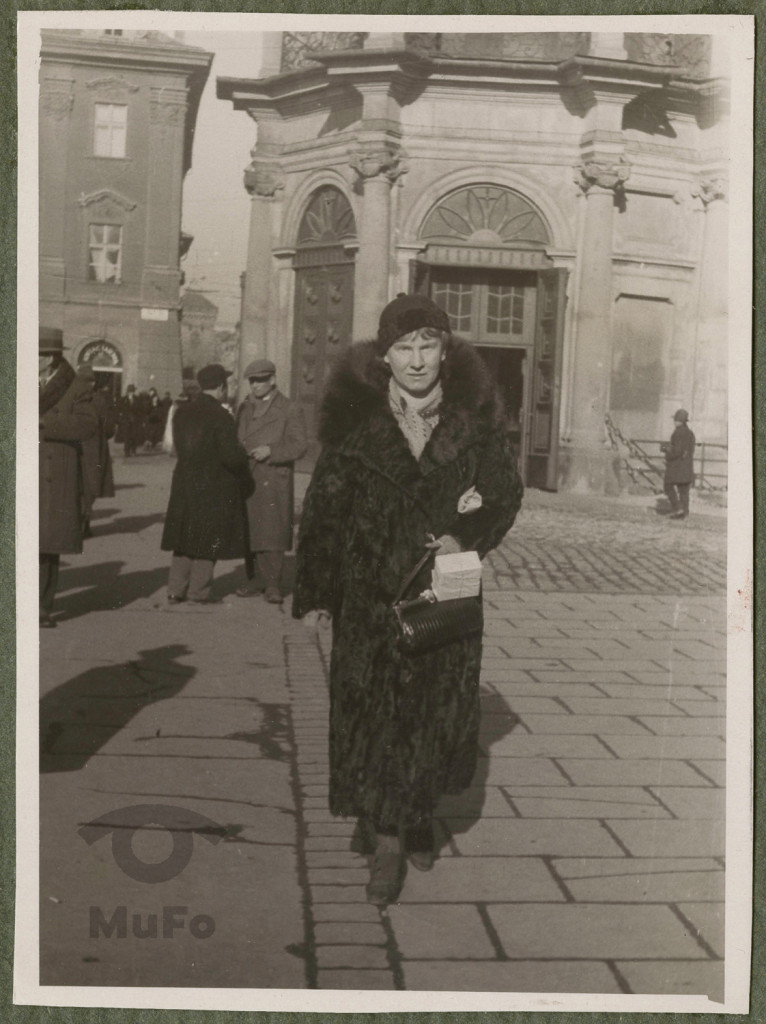 Karola Karyłowska idąca, portret w plenerze , w tle kruchta kościoła NMP, narożna kamienica pierzei Rynku Gł. wylot ulicy, linia AB