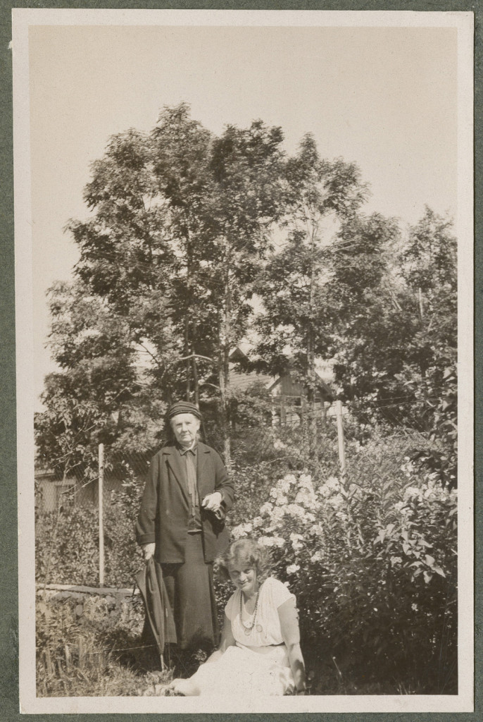 Maria Kosińska stoi i Zofia Mussilowa siedząca w ogrodzie latem, portret