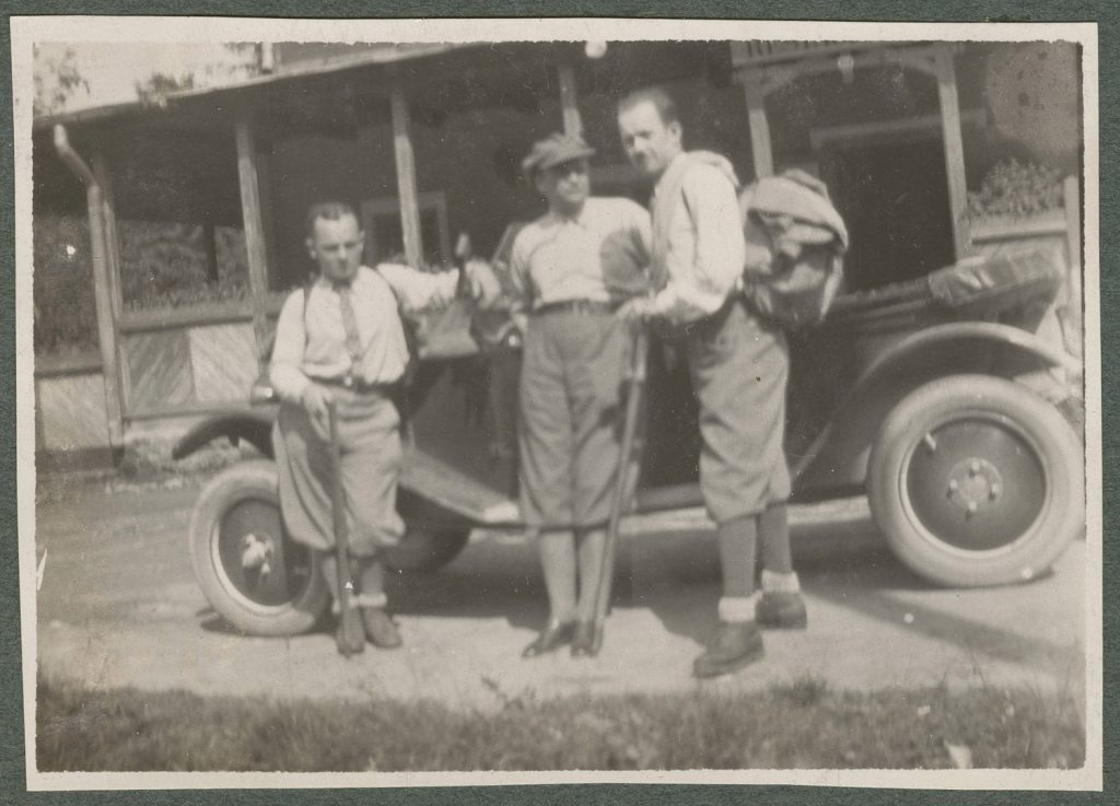 Trzej turyści na tle samochodu, portret w plenerze