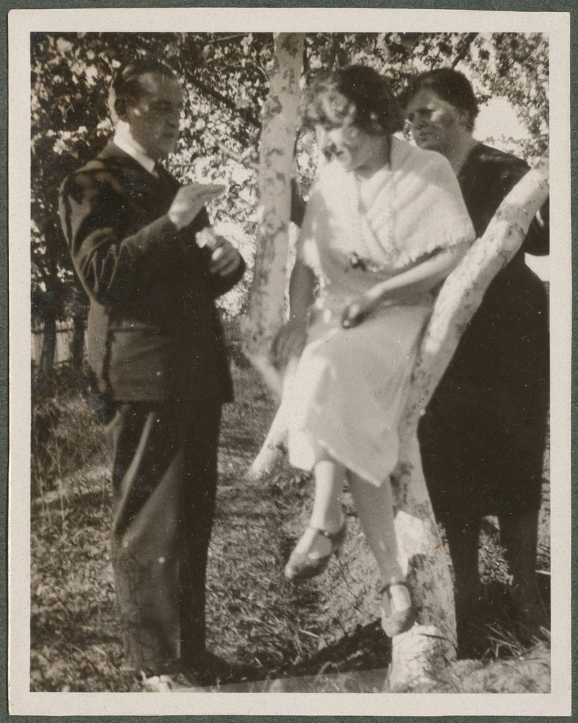 Trzy osoby pozujące wśród drzew owocowych, portret w plenerze