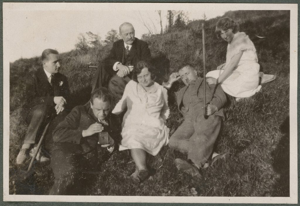 Sześć osób upozowanych na trawie, portret w plenerze