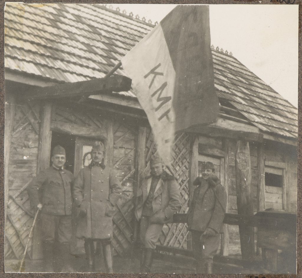 Czterej żołnierze armii Austro-Węgier na ganku budynku z flagą, portret