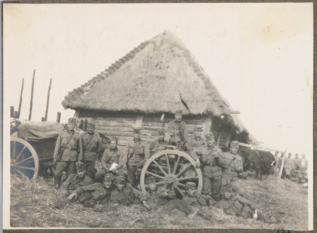Piętnastu żołnierzy armii Austro-Węgier przy dziale na tle chałupy, portret
