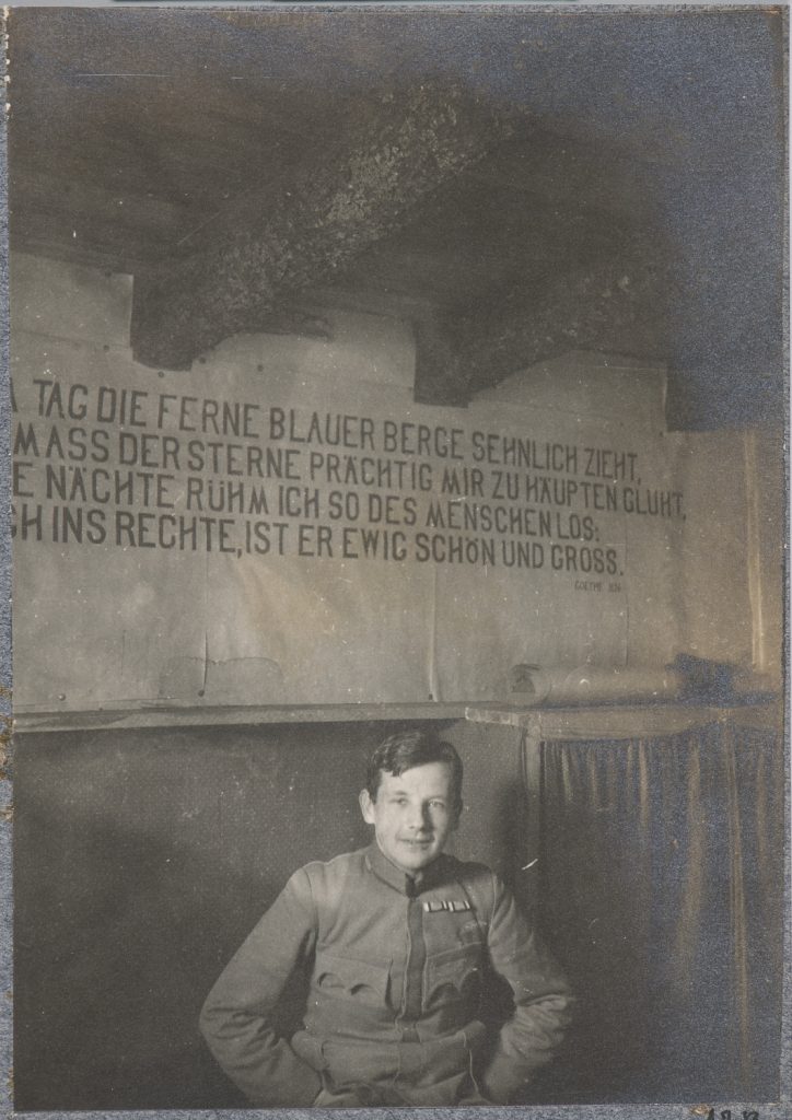 Alfred Sapieha siedzący pod ścianą z cytatem z Goethego, portret