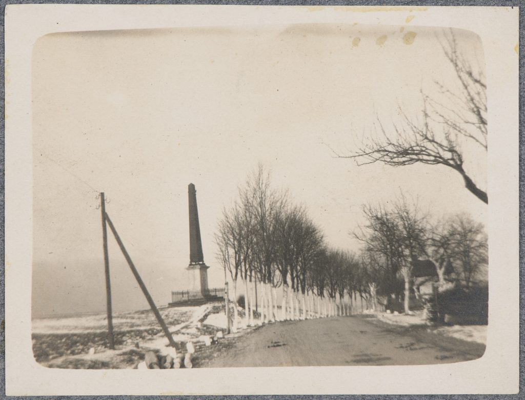 Obelisk przy drodze wysadzanej drzewami