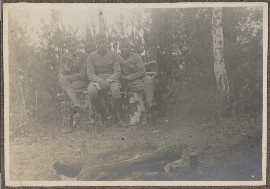 Trzej młodzi żołnierze armii Austro-Węgier siedzący na ławce, portret