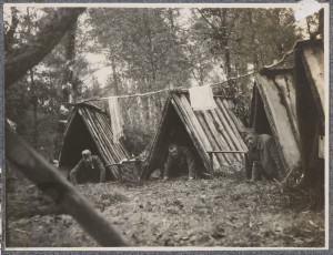 Trzej żołnierze armii Austro-Węgier wyglądający na czworakach z szałasów